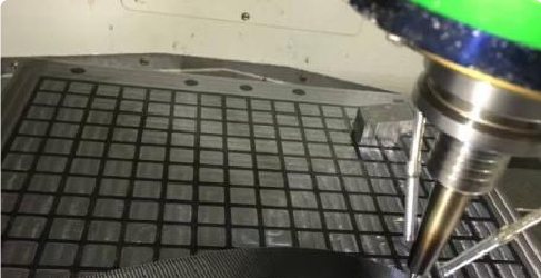 Five axis high speed CNC machine cutting an optical mould insert