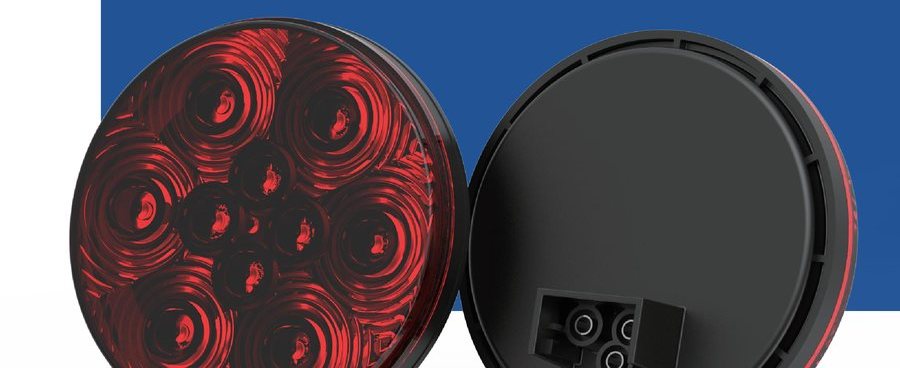 4 inch round red LED stop, turn and tail lamp beside its black rear housing